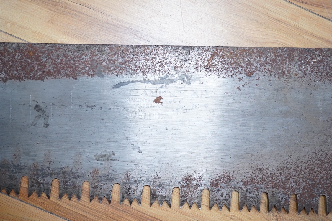 Three large Henry Disston and Sons, Philadelphia, U.S.A. early 20th century hand saws, the largest with a 5’ blade, the makers name still clear on two of the blades, all with similar style wood handles